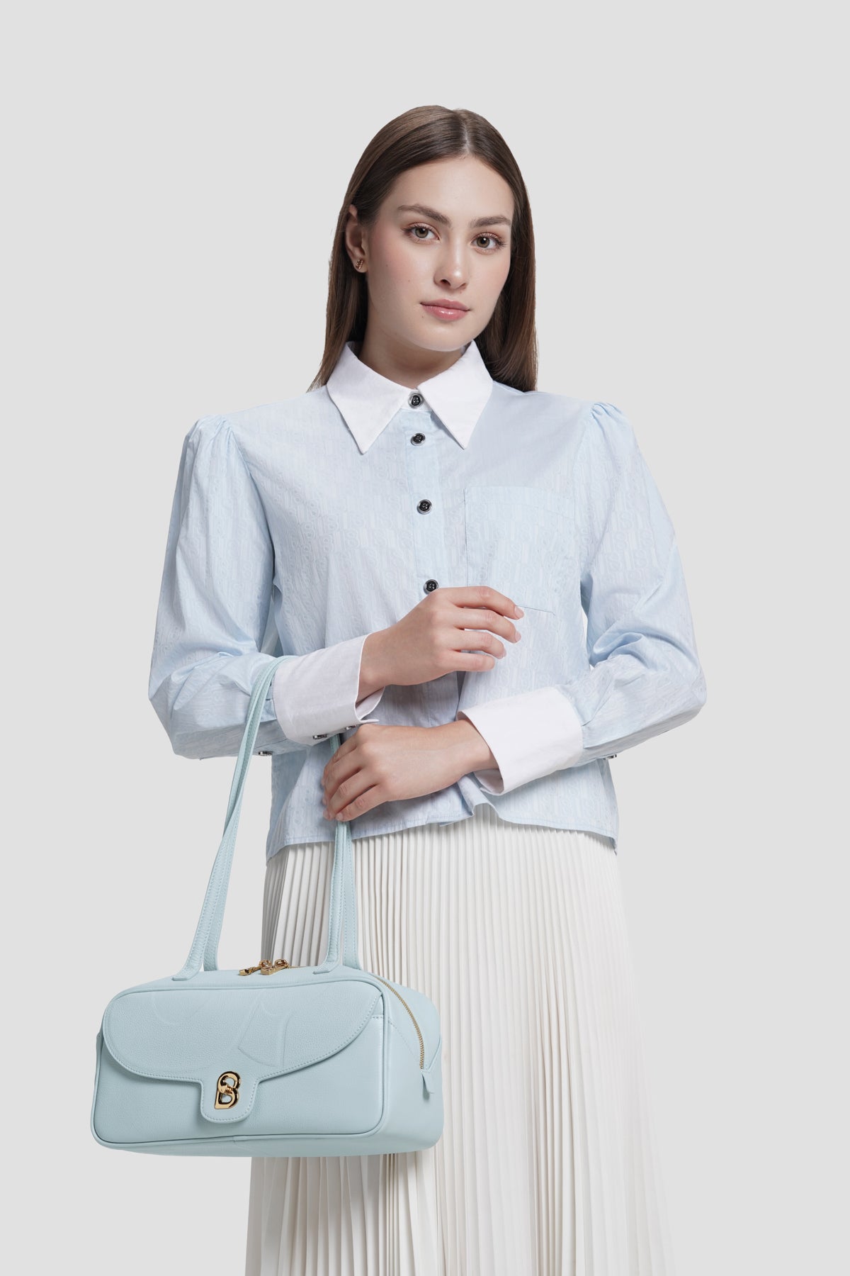 bria shoulder bag in baby blue by buttonscarves carried on wrist