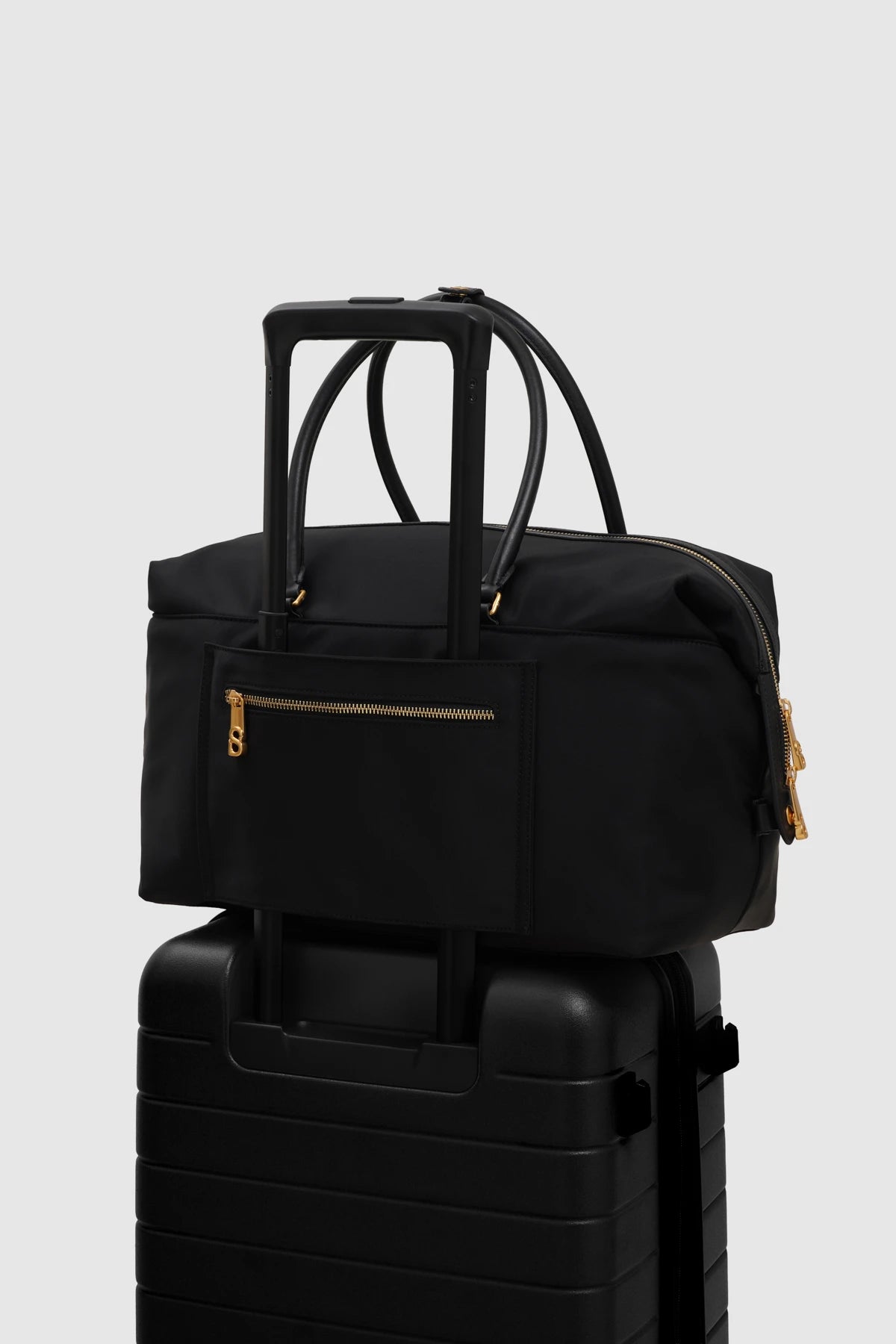 nara carryal bag in black by buttonscarves stack on suitcase