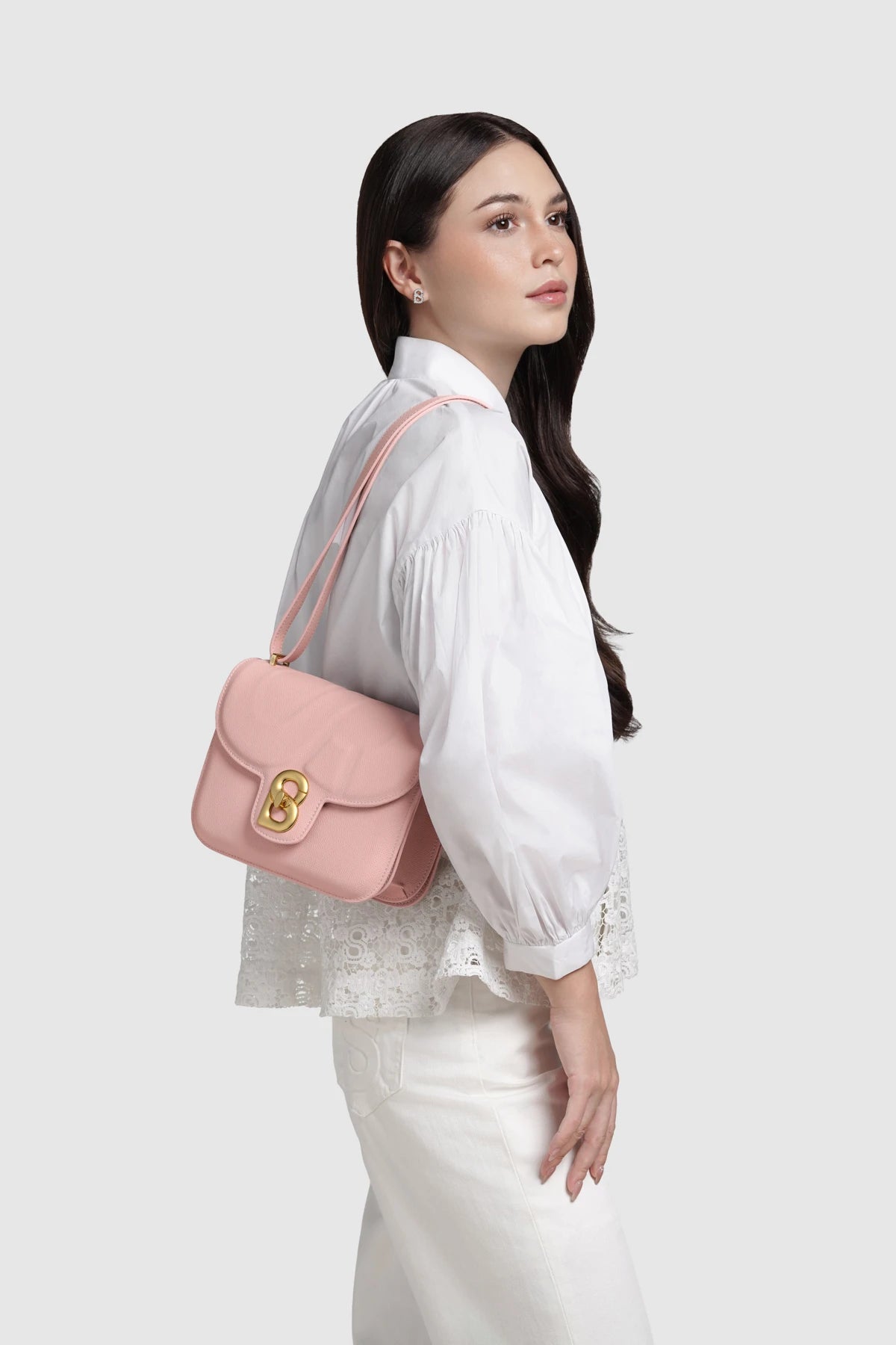 Model memakai Buttonscarves Alba Bag Medium warna dusty pink tampak samping