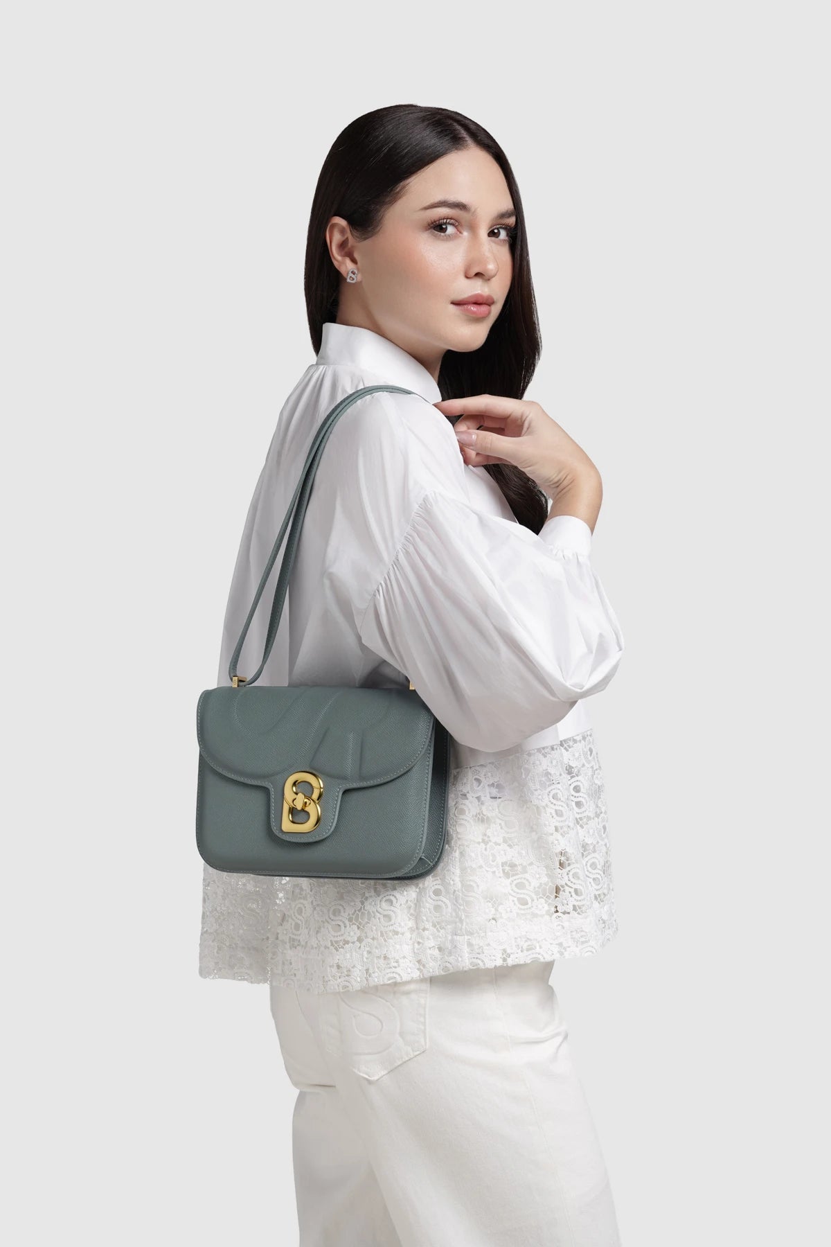 Model memakai Buttonscarves Alba Bag Medium warna hijau tampak samping