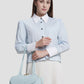 bria shoulder bag in baby blue by buttonscarves carried on wrist