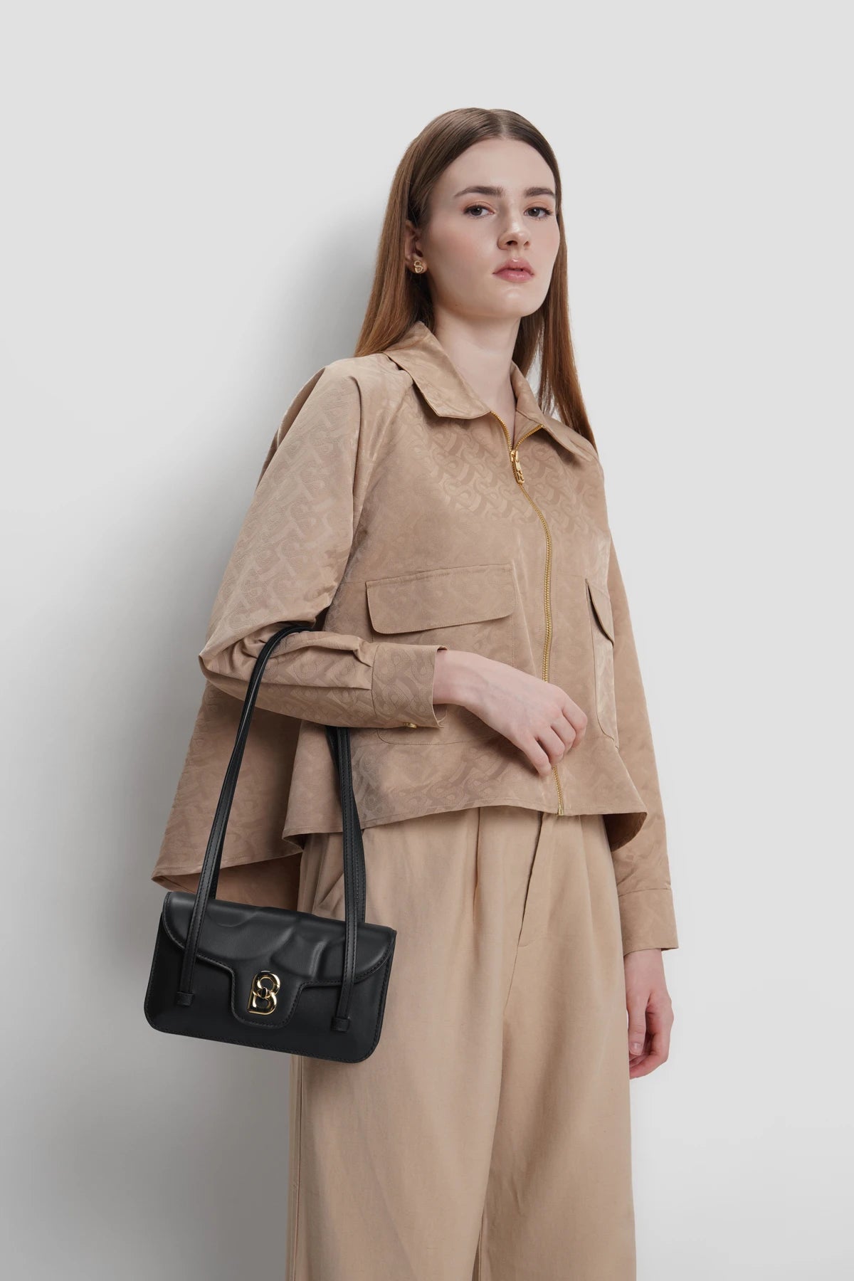 alka shoulder bag in black by buttonscarves carried on wrist