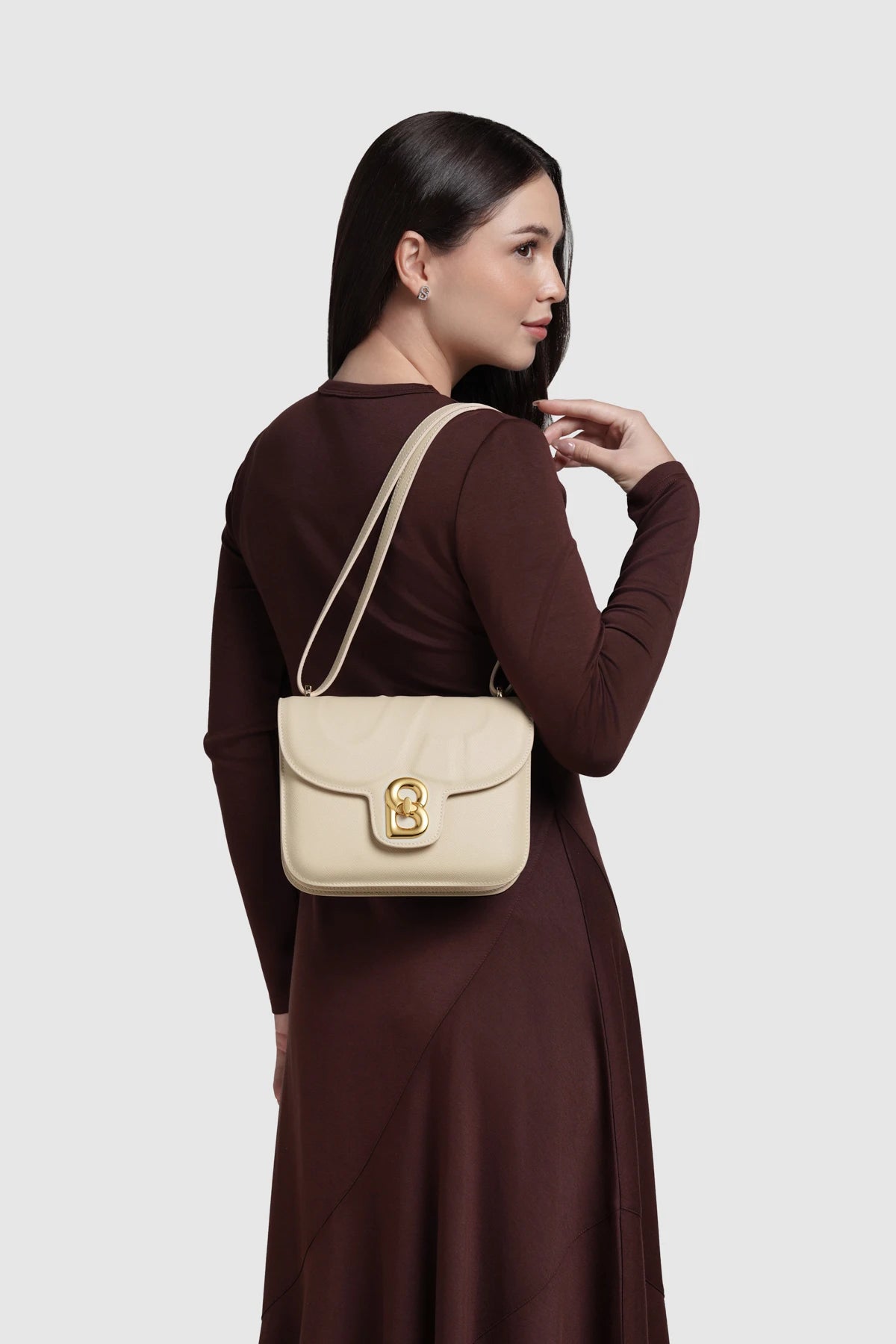 Model memakai Buttonscarves Alba Bag Medium warna putih chalk tampak samping