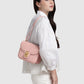 Model memakai Buttonscarves Alba Bag Medium warna dusty pink tampak samping