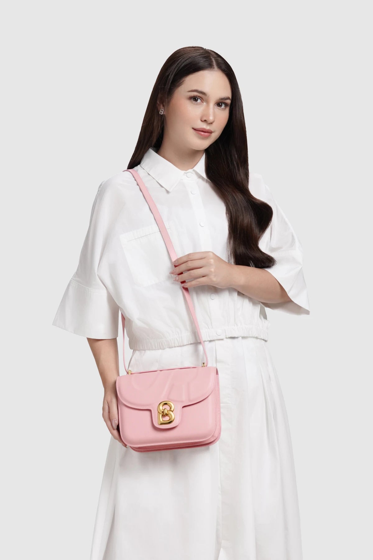 Model memakai tas Buttonscarves Alba Bag Medium warna pink 