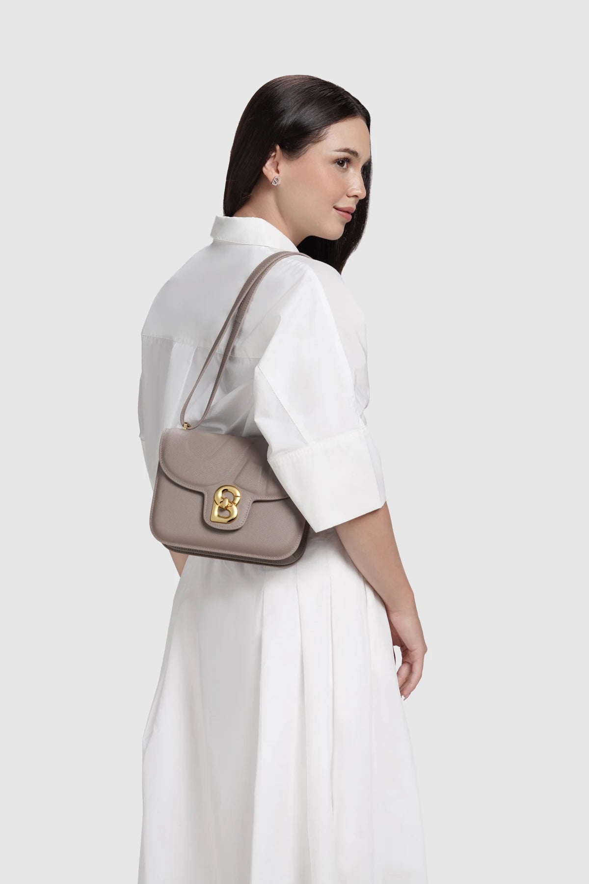 Model memakai Buttonscarves Alba Bag Medium warna Taupe tampak samping